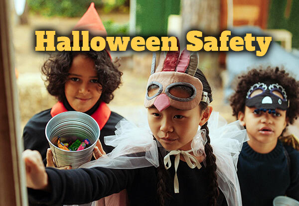 The words "Halloween Safety" with children in Halloween costumes trick-or-treating.