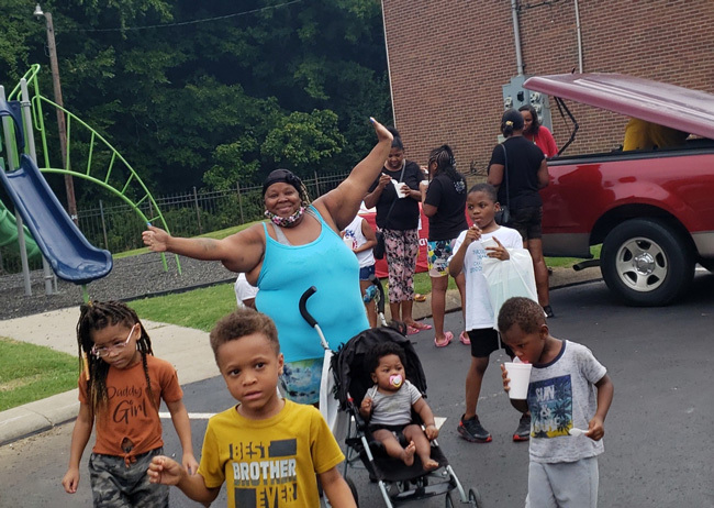 A group of children walking with an adult at a park.