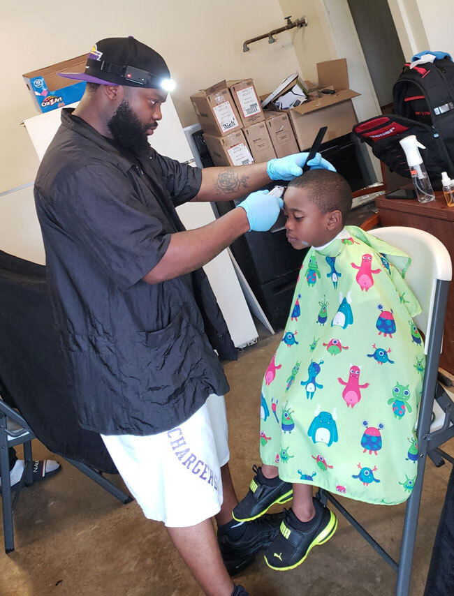 A boy receiving a haircut from a barber