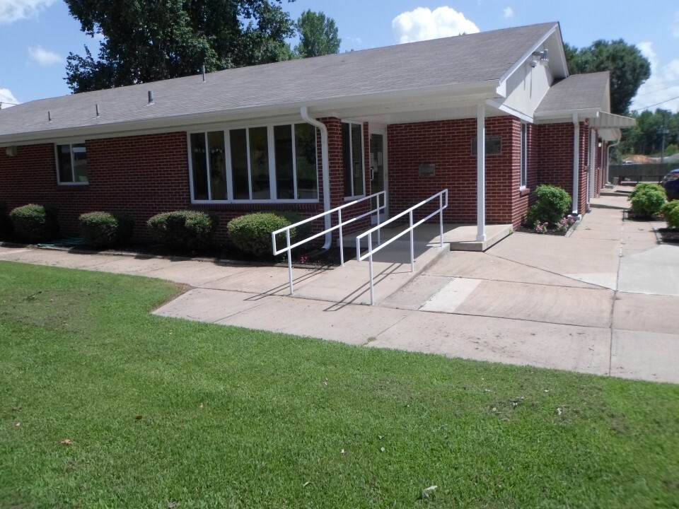 A sidewalk and hand-railings lead to the front door of the office. 