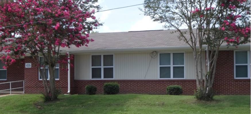 Small bushes and flowering trees are planted outside of the Center Pointe Apartments.