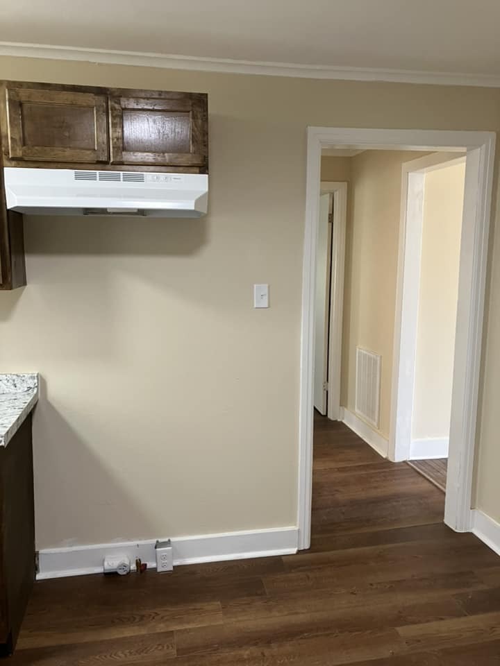 Wall in kitchen with small cabinets over vent hood.