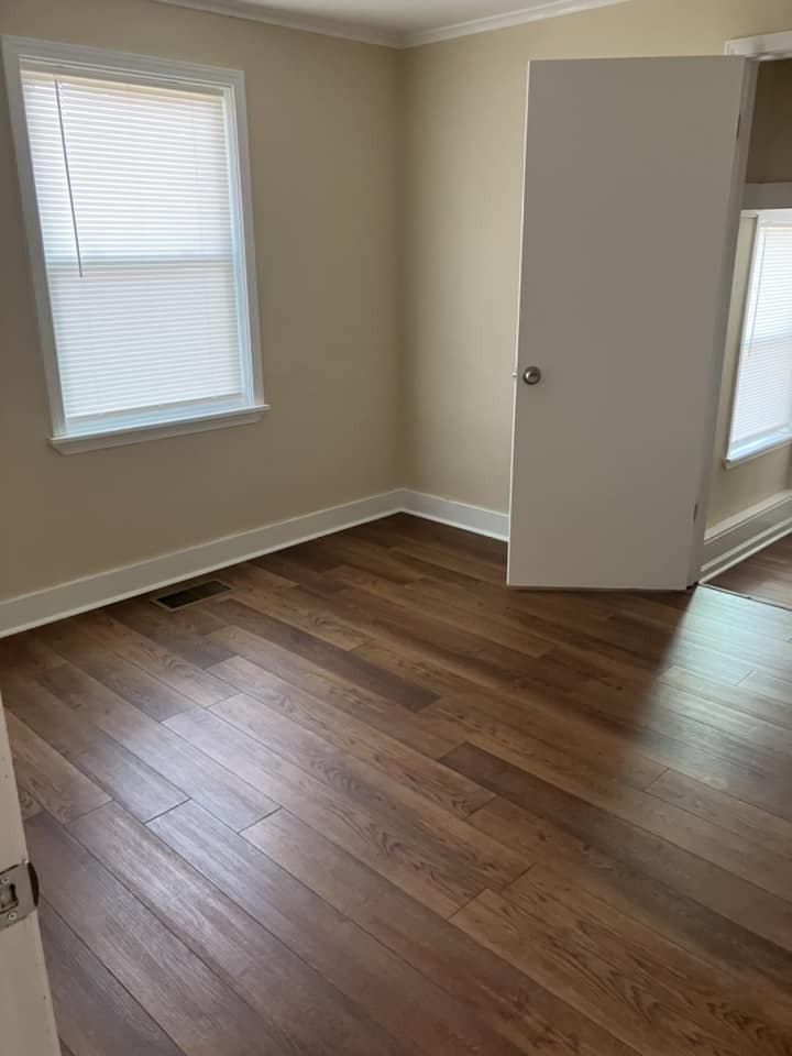 A door open in a room with a window.