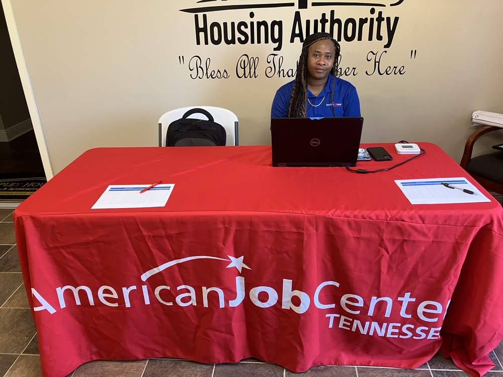 A lady sitting behind a table at the job fair.