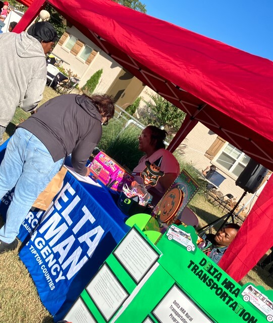 Delta Transportation Program table with people signing up and a lady manning the table.