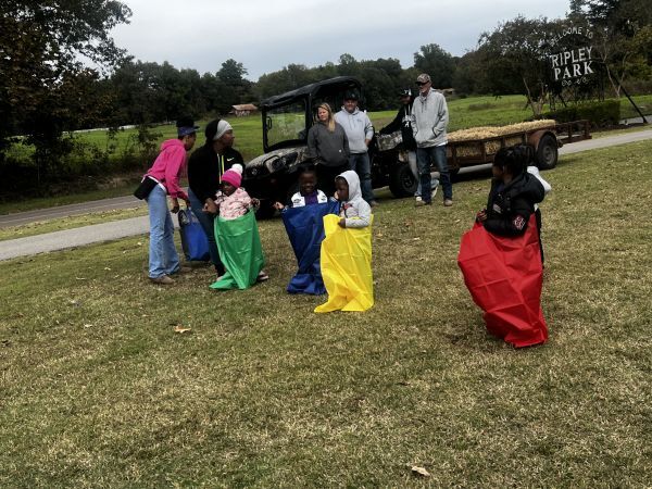 Four kids in different colored sacks, stand and get ready for sack races.