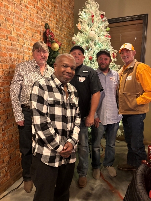 Five people at the the Christmas party in front of the tree.