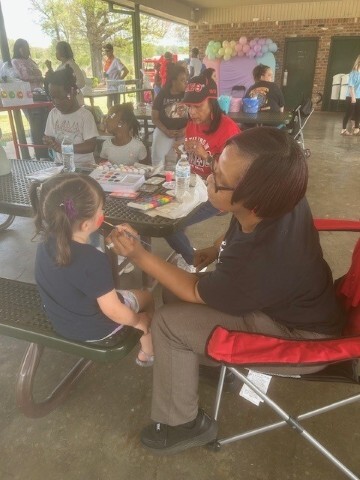 Covered area with children getting their face painted. 