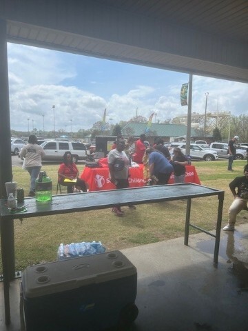 A table with onlookers talking with presenters. 