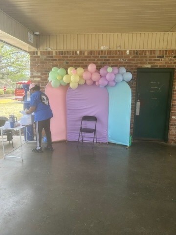 Backdrop with balloons and a chair. 