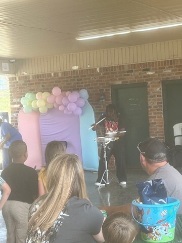 Young man playing an instrument with an audience watching. 