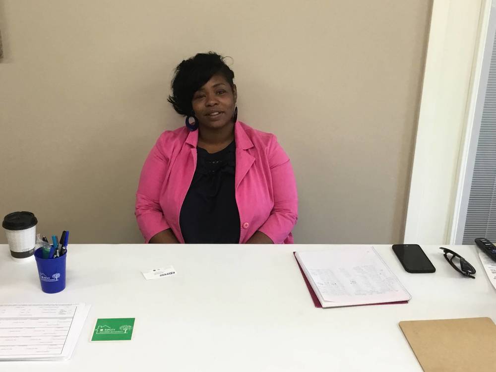 woman at job fair table in pink jacket